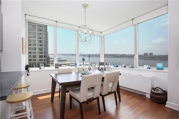 100 Riverside Blvd Unit 23-D, New York City, NY 10069 - dining area featuring dark wood finished floors, a chandelier, healthy amount of natural light, and a water view