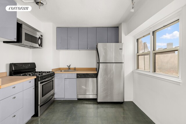 609 Columbus Ave Unit 12F, New York City, NY 10024 - kitchen featuring appliances with stainless steel finishes, a sink, light countertops, baseboards, and gray cabinets