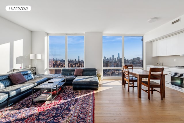 340 E 23rd St Unit Ph3D, New York City, NY 10010 - living room featuring light wood-style floors, a view of skyline, and expansive windows
