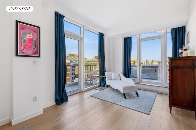sitting room with light wood-type flooring and baseboards