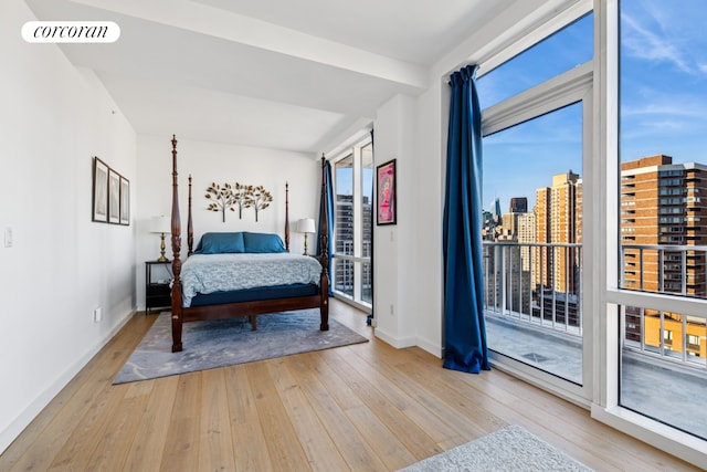 340 E 23rd St Unit Ph3D, New York City, NY 10010 - bedroom featuring hardwood / wood-style floors, multiple windows, access to exterior, and a city view