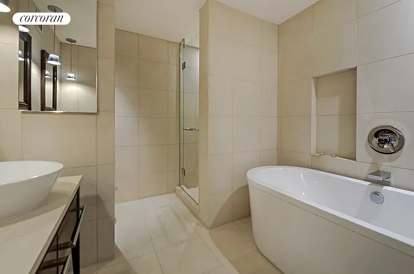 340 E 23rd St Unit Ph3D, New York City, NY 10010 - full bath featuring tile walls, a freestanding bath, a stall shower, tile patterned flooring, and vanity