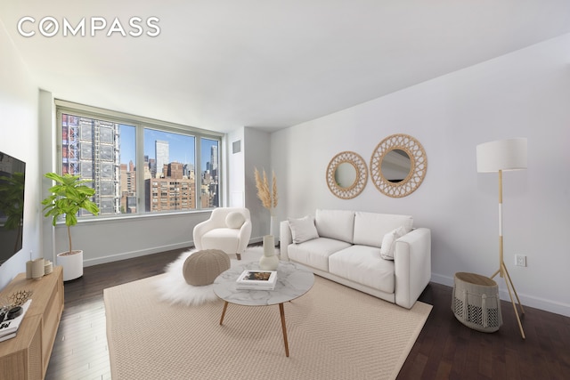 living room featuring baseboards, visible vents, a city view, and hardwood / wood-style flooring