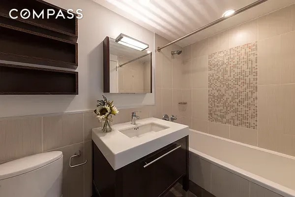 bathroom with toilet, bathing tub / shower combination, and vanity