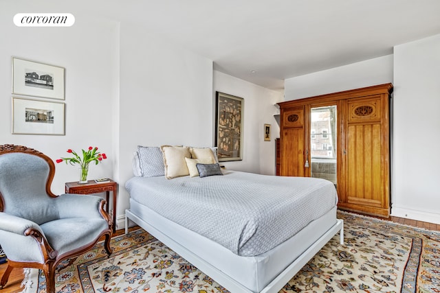bedroom featuring baseboards, light wood-type flooring, and visible vents
