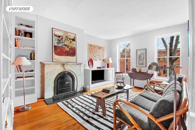 living area featuring wood finished floors and built in shelves