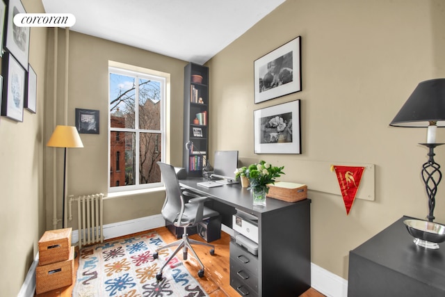 home office with baseboards, wood finished floors, and radiator