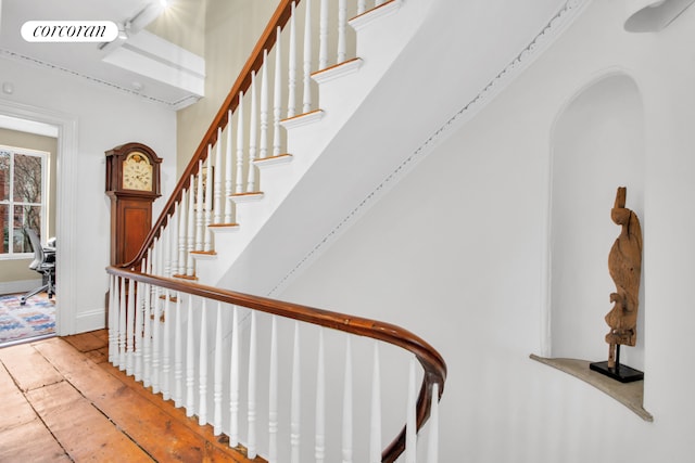 staircase with visible vents, arched walkways, and wood finished floors