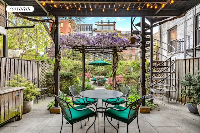 view of patio with stairway, fence, and outdoor dining area