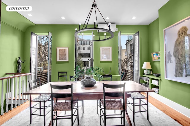 dining space featuring an inviting chandelier, recessed lighting, wood finished floors, and visible vents