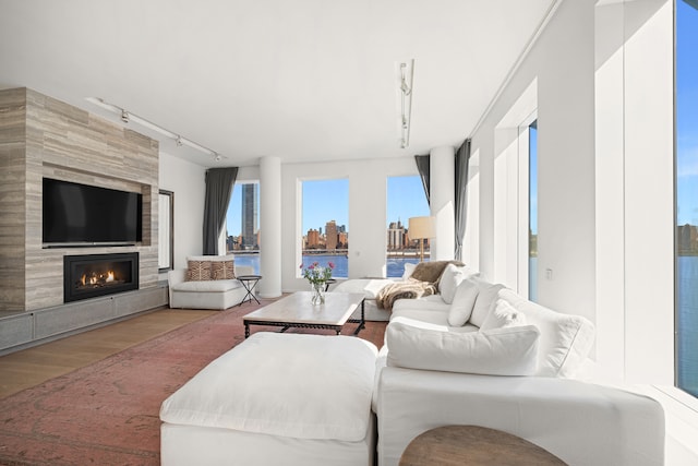1 John St Unit 9D, New York City, NY 11201 - living area with wood finished floors, a tiled fireplace, track lighting, and a skyline view