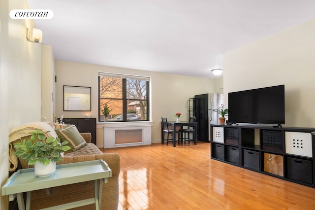 living area with visible vents and wood finished floors