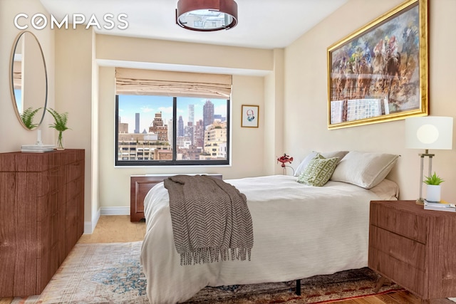 bedroom featuring a view of skyline and baseboards