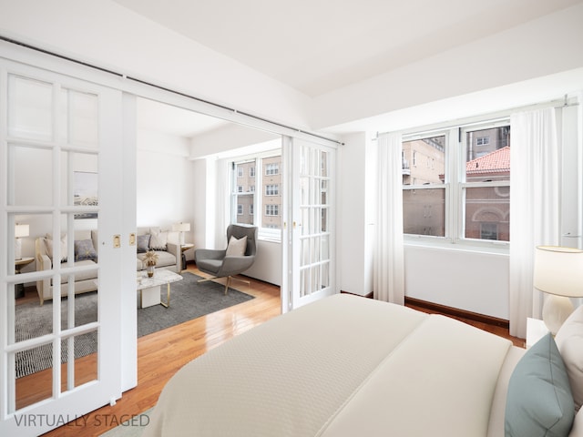 bedroom featuring french doors and light wood-style flooring