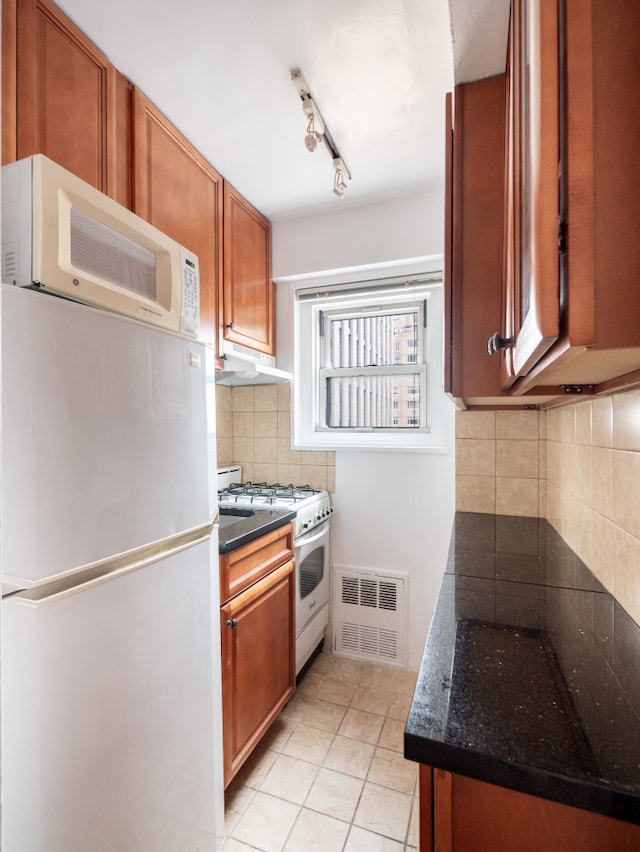 kitchen with brown cabinets, light tile patterned flooring, white appliances, decorative backsplash, and visible vents