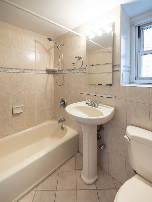 full bathroom featuring tile patterned flooring, washtub / shower combination, toilet, and tile walls
