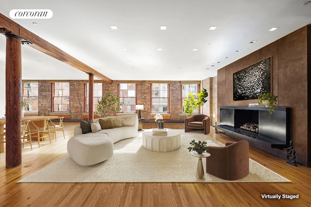 30 Crosby St Unit 4A, New York City, NY 10013 - living room with brick wall, ornate columns, and light wood-type flooring