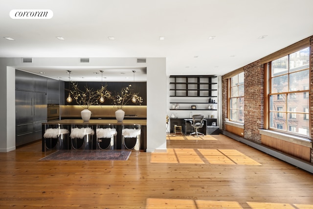 30 Crosby St Unit 4A, New York City, NY 10013 - living area with brick wall, wood-type flooring, a fireplace, a baseboard radiator, and recessed lighting