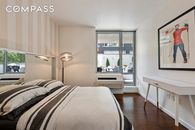 444 W 19th St Unit 201, New York City, NY 10011 - bedroom with dark wood finished floors, a wall mounted air conditioner, and baseboards