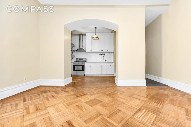 576 5th St Unit B2, New York City, NY 11215 - unfurnished living room featuring arched walkways, a sink, and baseboards