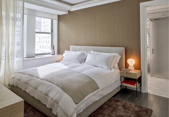 bedroom with ornamental molding and dark wood-style floors