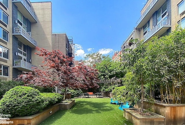 view of home's community featuring a yard and a garden