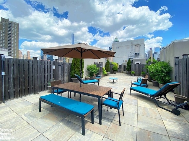 view of patio / terrace with fence and a city view