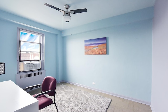 office space featuring ceiling fan, baseboards, radiator heating unit, and cooling unit