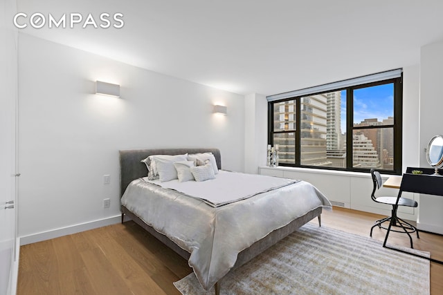 bedroom featuring baseboards and wood finished floors