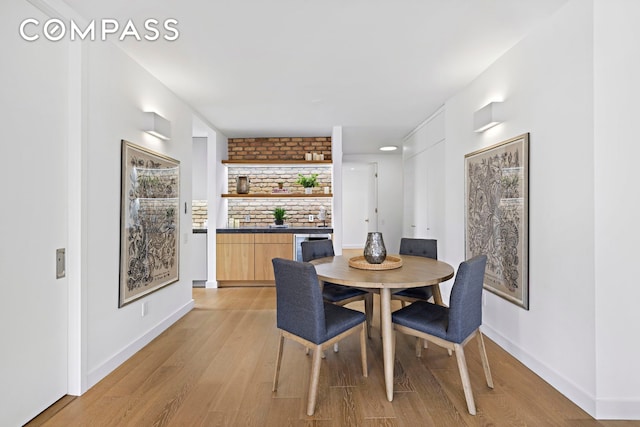 dining area featuring light wood-style floors and baseboards