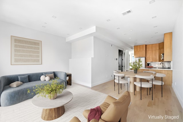 living room with light wood-style flooring and baseboards