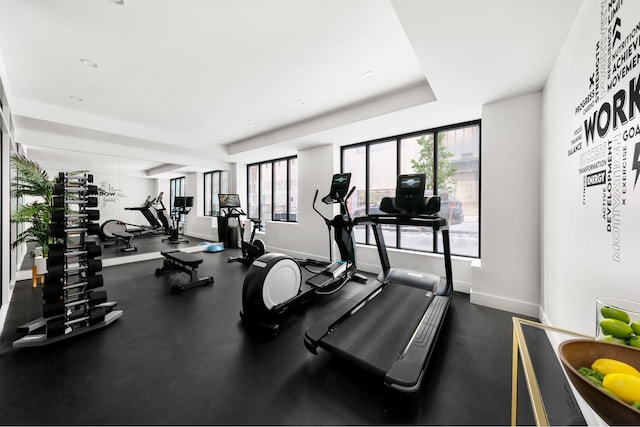 427 E 90th St Unit Ph10, New York City, NY 10128 - exercise room featuring healthy amount of natural light, baseboards, and a tray ceiling