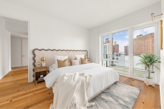 427 E 90th St Unit Ph10, New York City, NY 10128 - bedroom with access to exterior, light wood finished floors, and a city view