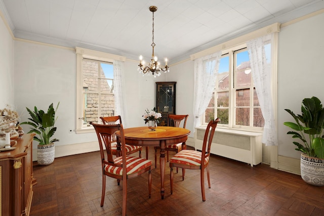 dining area with radiator, ornamental molding, a wealth of natural light, and a chandelier