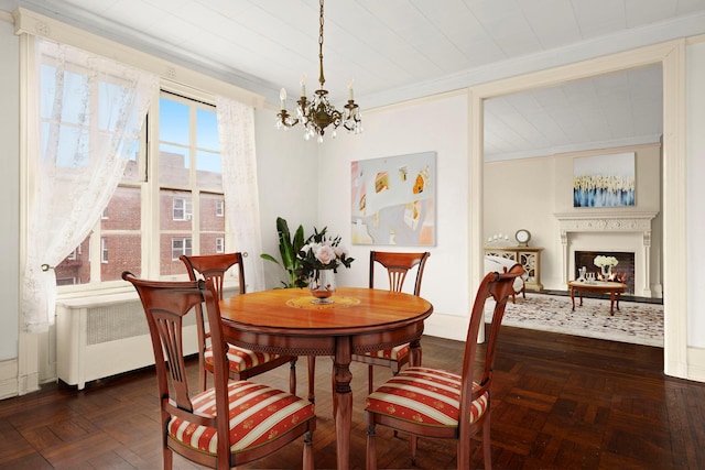 dining space with crown molding, a warm lit fireplace, an inviting chandelier, and radiator