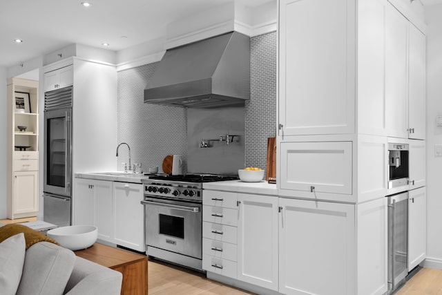 141 5th Ave Unit 3A, New York City, NY 10010 - kitchen with high end stainless steel range, wall chimney exhaust hood, wine cooler, refrigerator, and a sink
