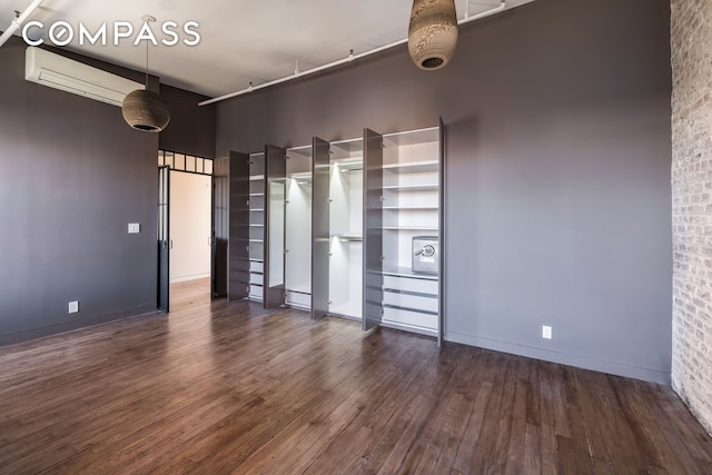 705 Driggs Ave Unit 13, New York City, NY 11211 - spare room featuring a wall mounted air conditioner, wood finished floors, a high ceiling, and baseboards