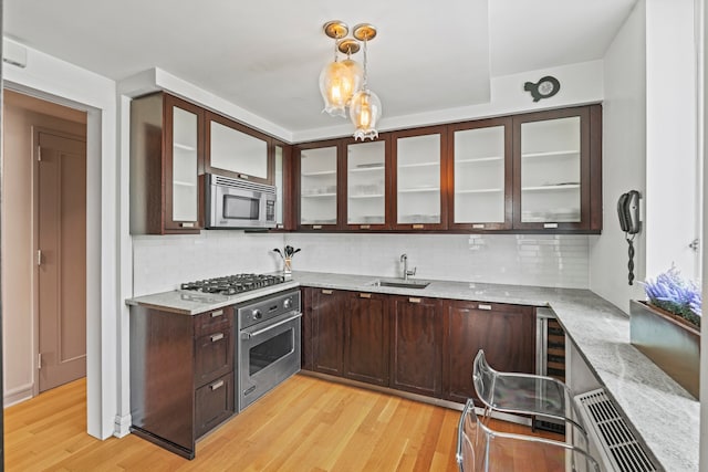 80 Riverside Blvd Unit 16-P, New York City, NY 10069 - kitchen featuring appliances with stainless steel finishes, a sink, light wood finished floors, and dark brown cabinetry