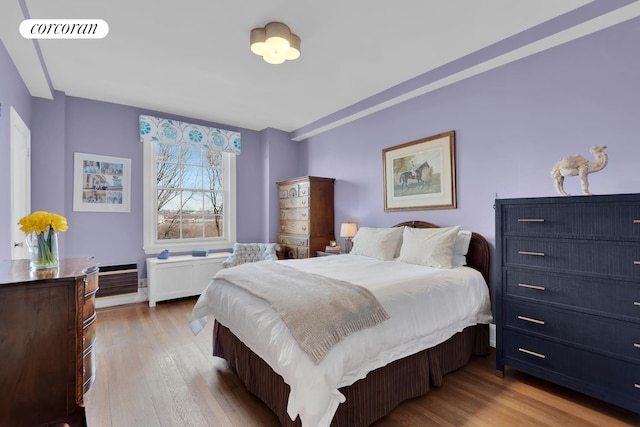bedroom featuring radiator, wood finished floors, and visible vents