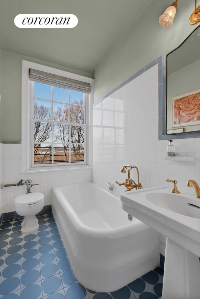 full bath with toilet, tile patterned floors, tile walls, and a bath