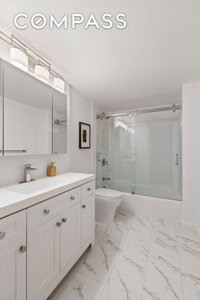 full bath featuring combined bath / shower with glass door, toilet, marble finish floor, and vanity