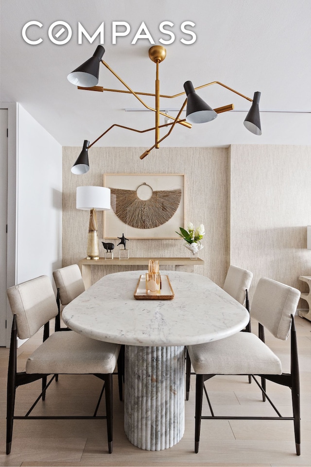 dining area with wood finished floors and wallpapered walls