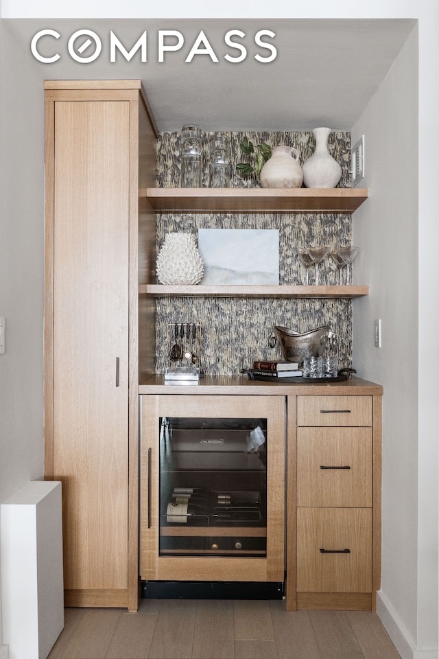 bar with wine cooler, a bar, and baseboards