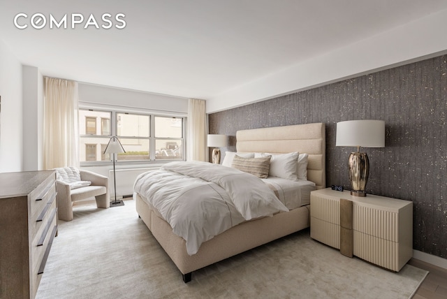 bedroom featuring baseboards, light wood-type flooring, and wallpapered walls