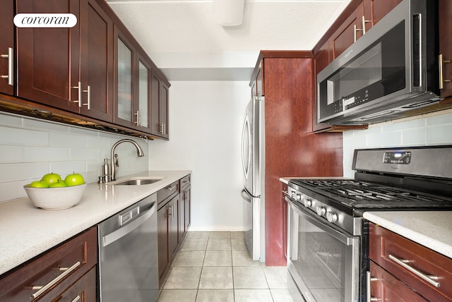 68 Bradhurst Ave Unit 6V, New York City, NY 10030 - kitchen with stainless steel appliances, a sink, tasteful backsplash, light tile patterned floors, and light countertops