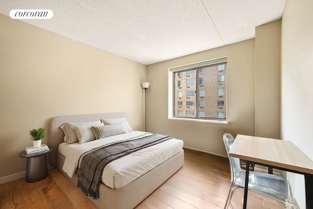 68 Bradhurst Ave Unit 6V, New York City, NY 10030 - bedroom with wood finished floors, baseboards, and a textured ceiling