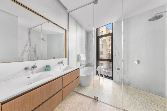 full bath featuring speckle patterned floor, a marble finish shower, a freestanding tub, and double vanity