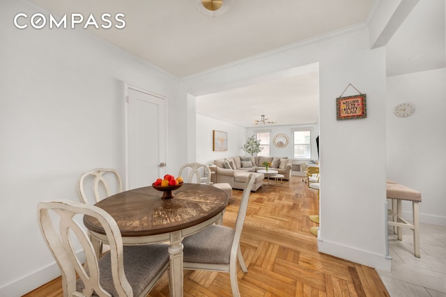 325 E 77th St Unit 1E, New York City, NY 10075 - dining area with ornamental molding, baseboards, and a chandelier