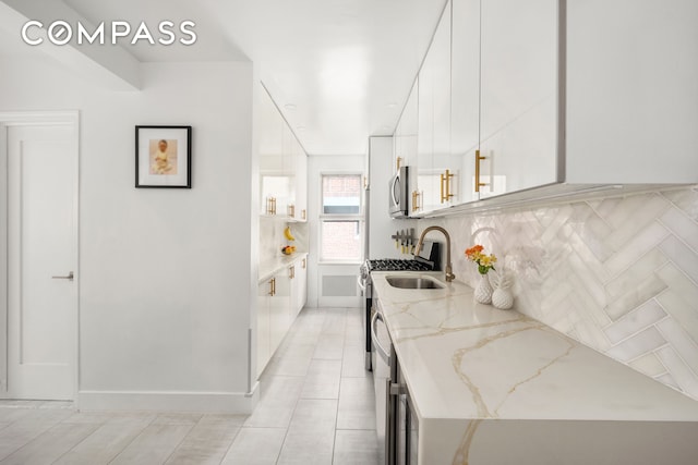 325 E 77th St Unit 1E, New York City, NY 10075 - kitchen featuring stainless steel microwave, white cabinetry, a sink, tasteful backsplash, and modern cabinets