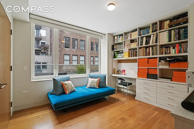 living area with baseboards and wood finished floors